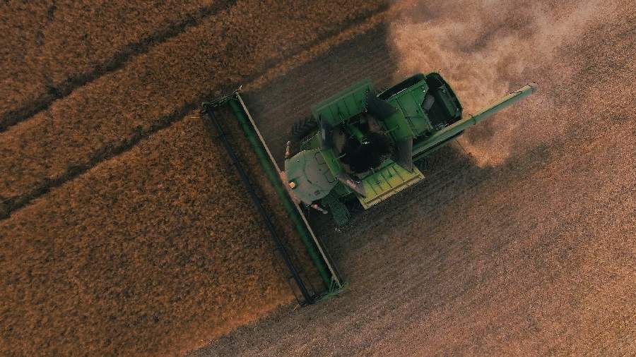 tractor recogiendo un campo de trigo