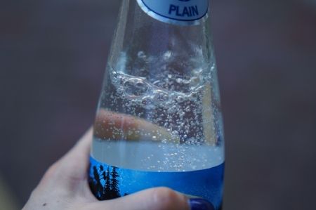Botella de agua carbonatada con pegatina azul