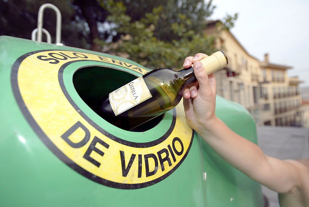 persona reciclando una botella de vidrio en contenedor de Ecovidrio