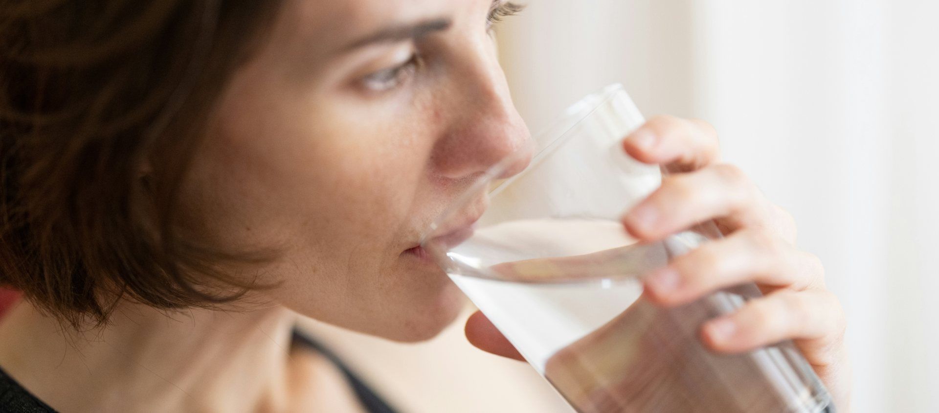 mujer bebiendo agua de vaso