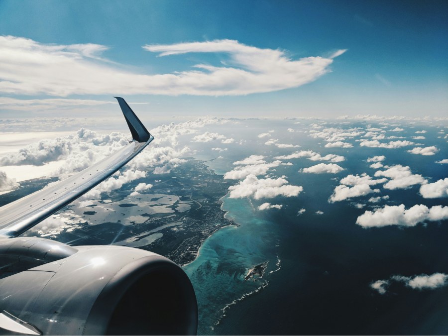 imagen de ala de avion volando por encima de una costa
