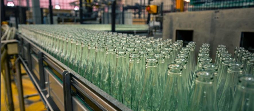 fila de botellas de vidrio en una empresa envadora